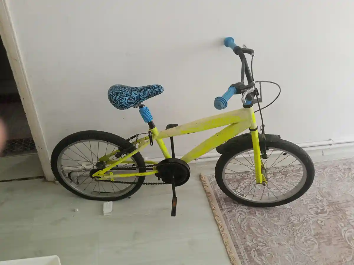 Sarı renkli çocuk bisikleti sadece arka tekeri patlak