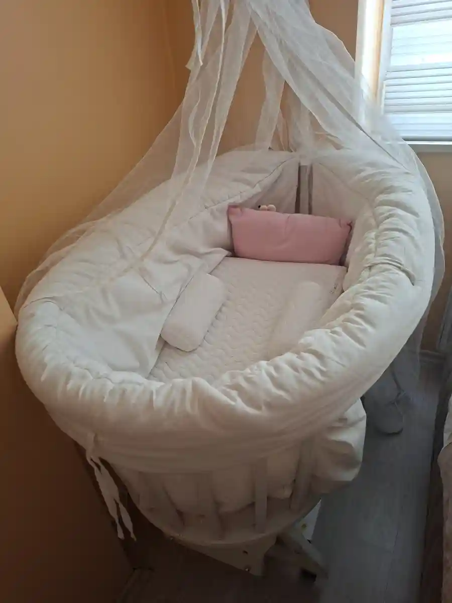 Beyaz yuvarlak bebek beşiği