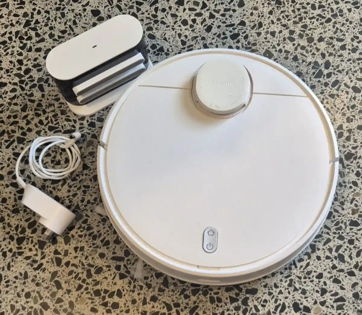 Beyaz robot süpürge ve şarj aleti